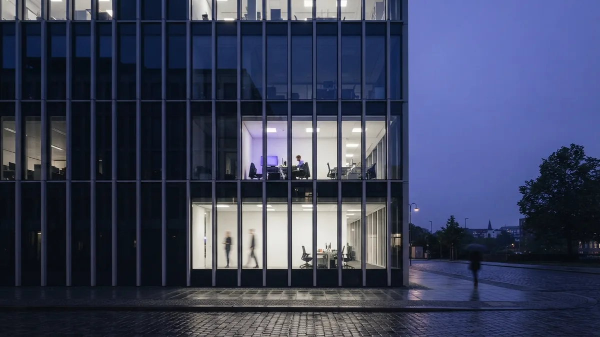 Glass European office building at blue hour with clean architectural lines